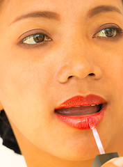 Image showing Applying Lipgloss On Lips To Make Girl Beautiful