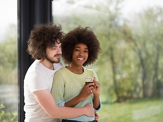 Image showing happy multiethnic couple relaxing at modern home indoors