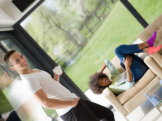 Image showing multiethnic couple relaxing at  home with laptop computers