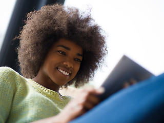 Image showing young african american woman at home using digital tablet