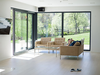 Image showing young man using a mobile phone  at home