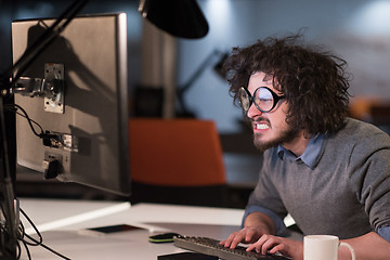 Image showing man working on computer in dark startup office