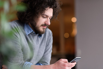 Image showing Young casual businessman holding smartphone