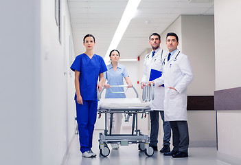 Image showing group of doctors with gurney at hospital