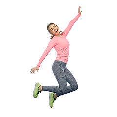 Image showing happy smiling sporty young woman jumping in air