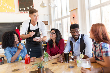 Image showing waiter and friends with menu and drinks at bar