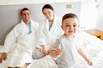 Image showing happy family in bed at home or hotel room