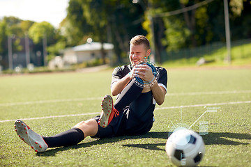 Image showing injured soccer player with ball on football field