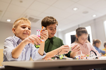 Image showing happy children building robots at robotics school