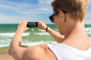 Image showing man with smartphone photographing on summer beach