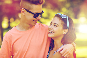 Image showing happy teenage couple looking at each other in park