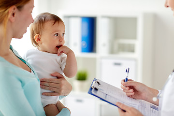 Image showing woman, baby and doctor with clipboard at clinic