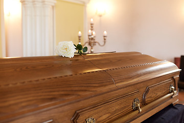 Image showing rose flower on wooden coffin at funeral in church