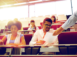 Image showing teacher giving tests to students at lecture