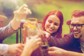 Image showing happy friends clinking glasses at summer garden