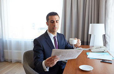 Image showing businessman reading newspaper and drinking coffee