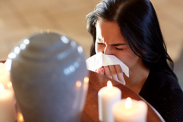 Image showing woman with cremation urn at funeral in church