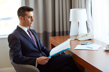 Image showing businessman with papers working at hotel room