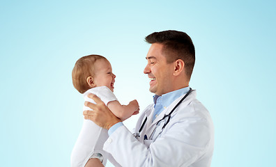 Image showing happy doctor or pediatrician with baby over blue