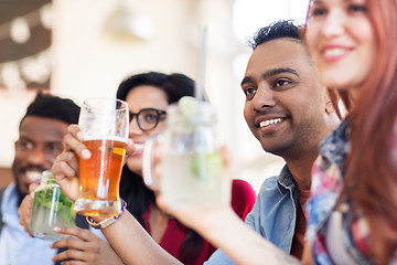 Image showing happy friends with drinks at restaurant