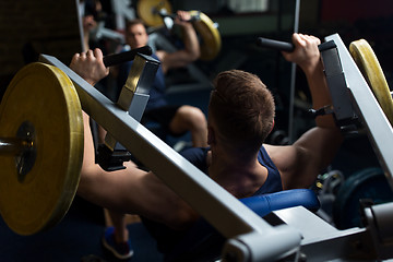 Image showing man doing chest press on exercise machine in gym