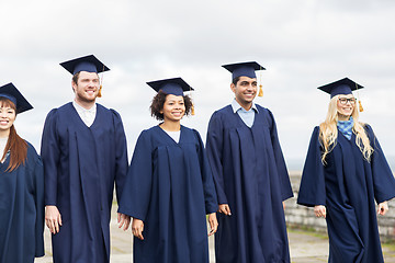 Image showing happy students or bachelors in mortar boards