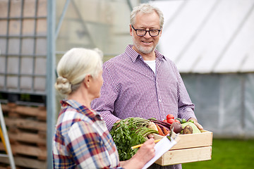 Image showing senior couple with box of vegetables on farm