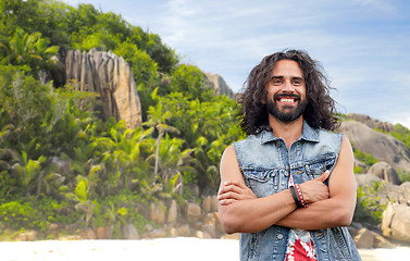 Image showing smiling hippie man in denim vest on island beach