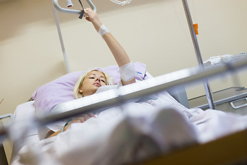 Image showing Bedridden female patient recovering after surgery in hospital care.