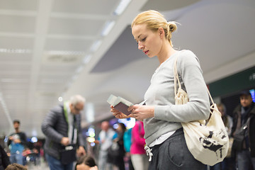 Image showing Casual woman waiting for her flight at airport.