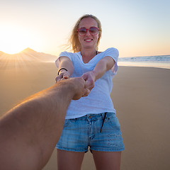 Image showing Romantic couple, holding hands,  on beach.