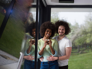 Image showing happy multiethnic couple relaxing at modern home indoors