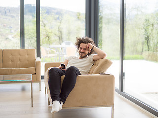 Image showing young man using a mobile phone  at home