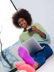 Image showing black woman in the living room on the floor