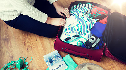 Image showing close up of woman packing travel bag for vacation