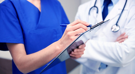 Image showing close up of doctors with clipboard at hospital