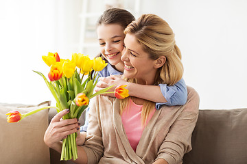Image showing happy girl giving flowers to mother at home