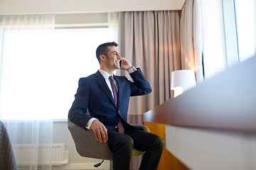 Image showing businessman calling on smartphone at hotel room