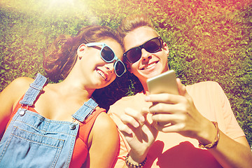 Image showing happy teenage couple smartphone lying on grass