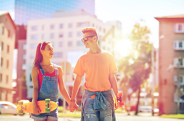 Image showing teenage couple with skateboards on city street