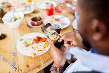 Image showing hands with smartphone picturing food at restaurant