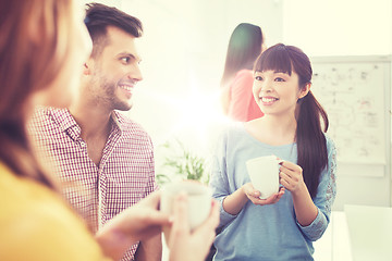 Image showing happy creative team drinking coffee at office