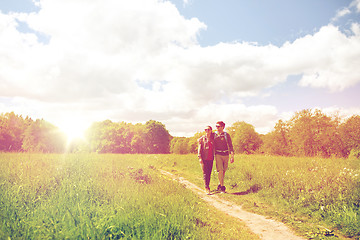 Image showing happy couple with backpacks hiking outdoors