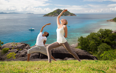 Image showing couple doing yoga over natural background and sea