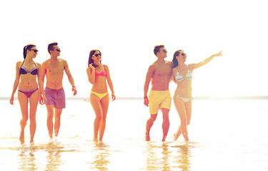 Image showing smiling friends in sunglasses on summer beach