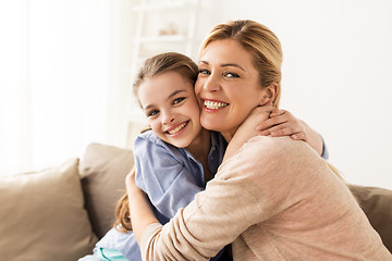 Image showing happy smiling family hugging on sofa at home