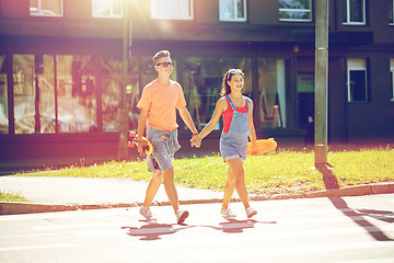 Image showing teenage couple with skateboards on city street