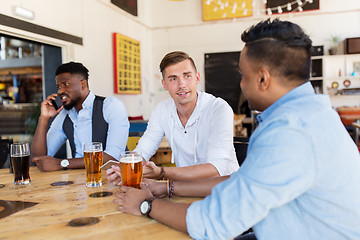 Image showing happy male friends drinking beer at bar or pub