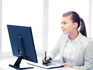 Image showing businesswoman with drawing tablet in office