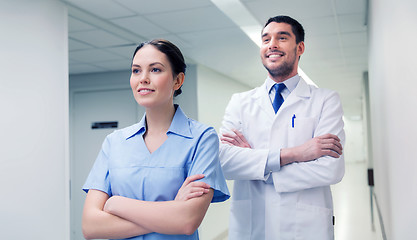 Image showing smiling doctor in white coat and nurse at hospital